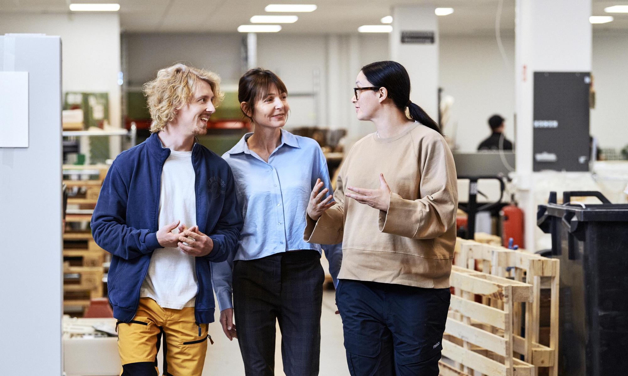 Three colleagues walking and having a meeting
